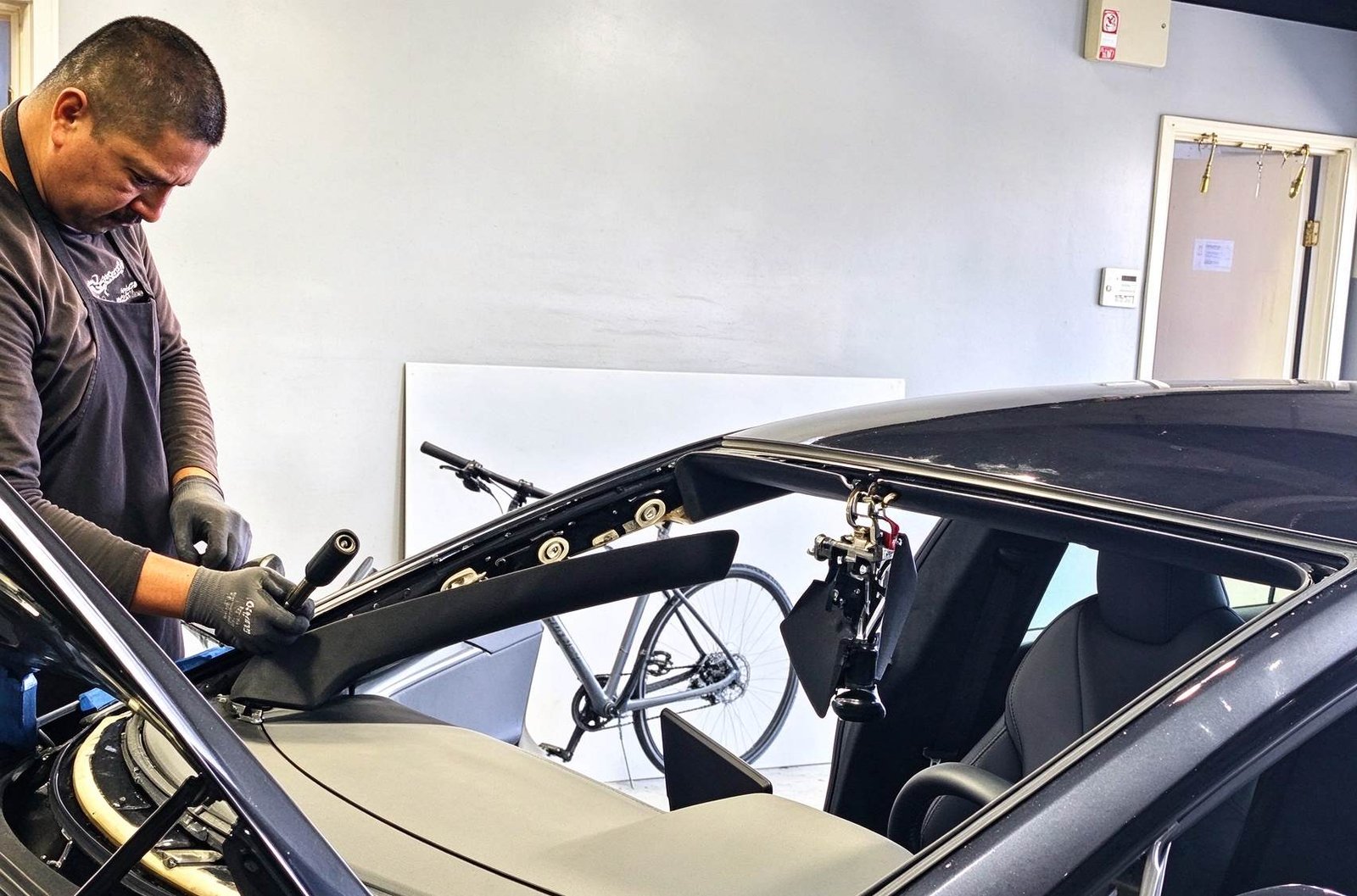 Technician carefully extruding direct glazing adhesive to prevent voids that cause windshield leaks
