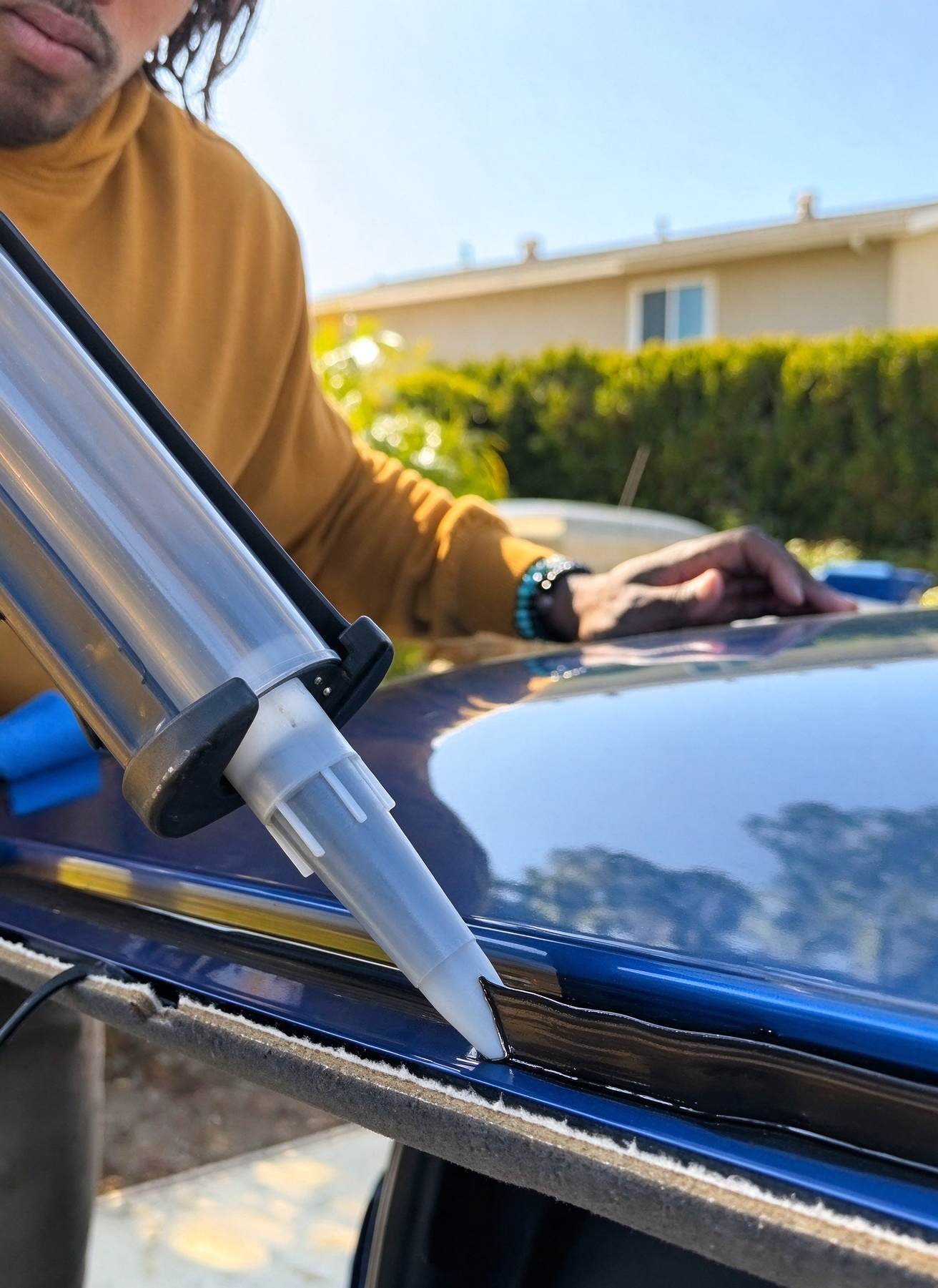 Close-up of precise triangular polyurethane adhesive bead extruded onto restored vehicle pinchweld
